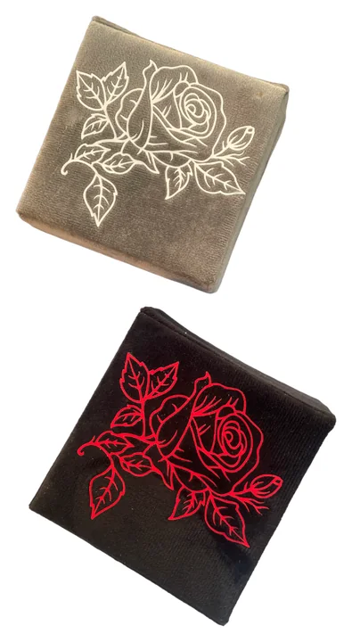 Due accessori quadrati beige e nero decorati con rose chiare e rosse
