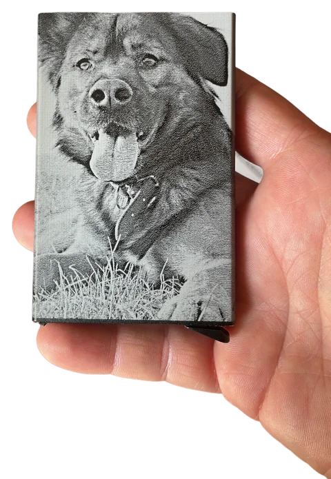Piccolo supporto rettangolare inciso con un lupo e un paesaggio, tenuto in mano
